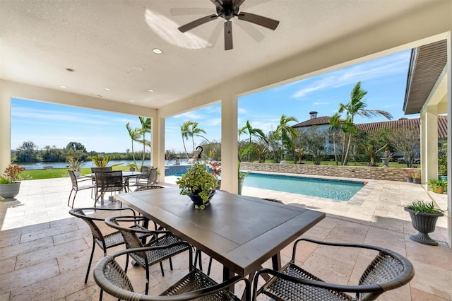 view of patio with ceiling fan and a water view