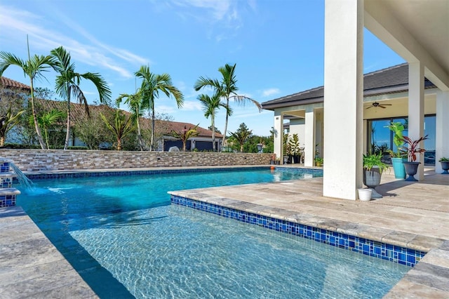 view of swimming pool with pool water feature and a patio