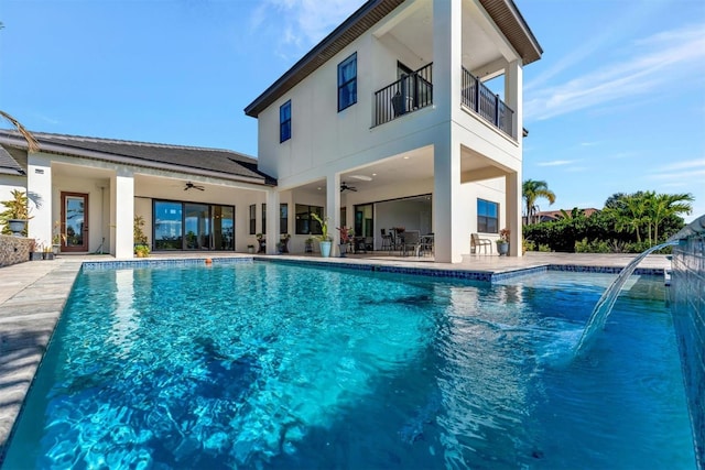 view of pool with pool water feature, ceiling fan, and a patio