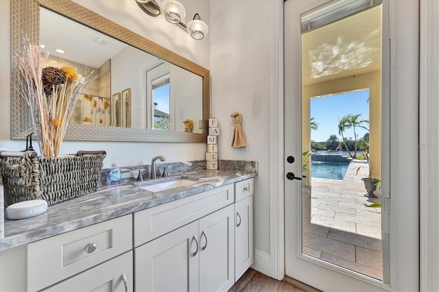 bathroom with hardwood / wood-style flooring, vanity, curtained shower, and a water view