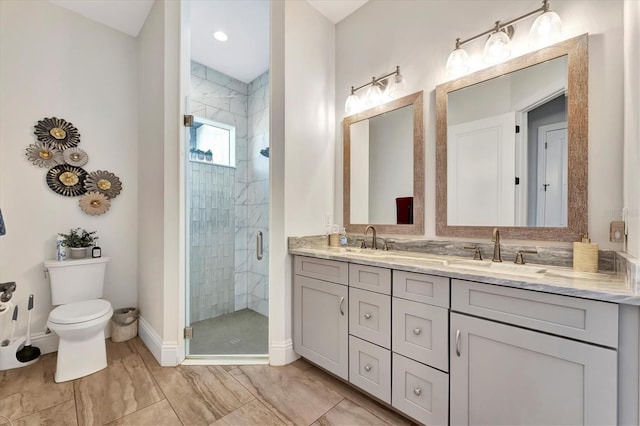 bathroom with vanity, toilet, and a shower with shower door