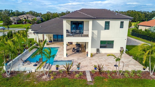 back of property with a balcony and a patio