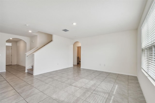 tiled spare room featuring plenty of natural light