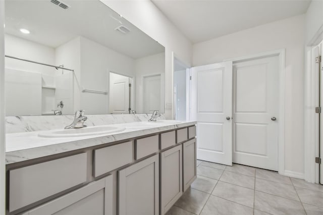 bathroom featuring tile patterned flooring, vanity, and walk in shower