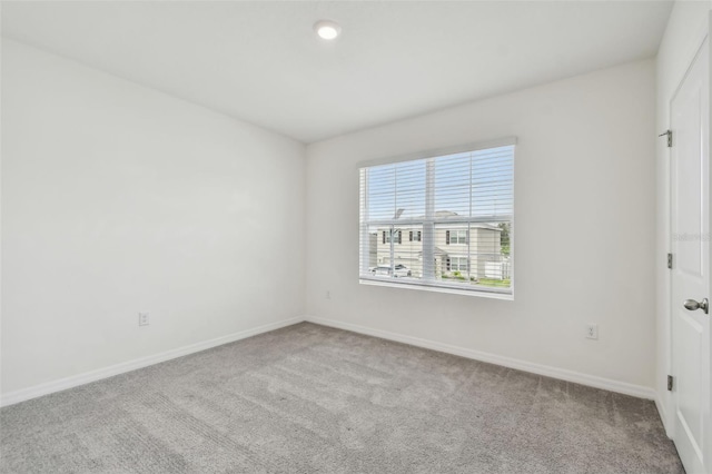 spare room featuring light colored carpet