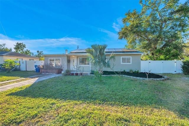 ranch-style house featuring solar panels and a front lawn