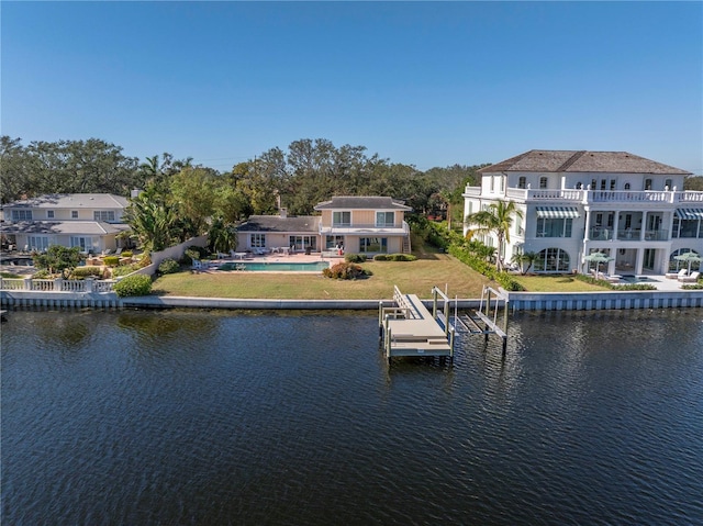 dock area with a yard, a balcony, and a water view