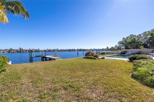 dock area with a lawn and a water view
