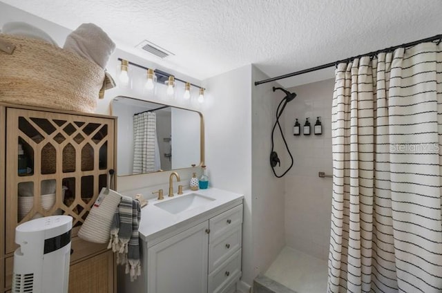 bathroom featuring a shower with curtain, vanity, and a textured ceiling