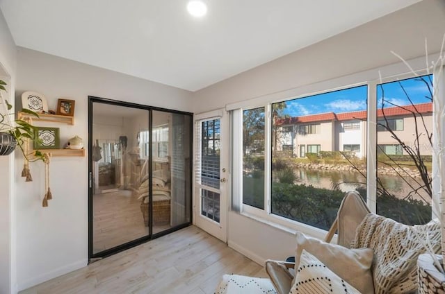 sunroom featuring a water view