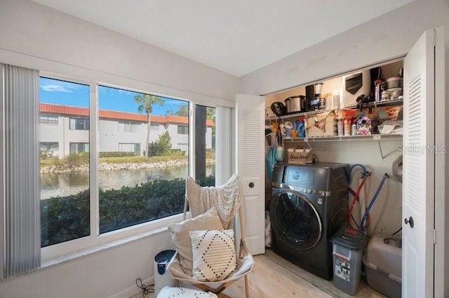 washroom featuring washer / dryer and a water view