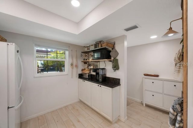 kitchen featuring white cabinets, white fridge, and light hardwood / wood-style floors