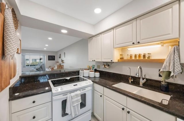 kitchen featuring dark stone countertops, sink, white cabinets, and white electric range