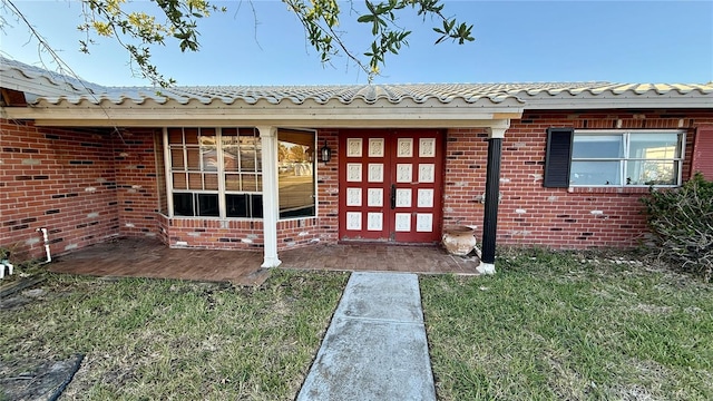 doorway to property with a lawn