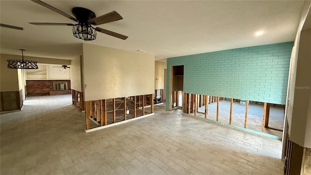 unfurnished room featuring ceiling fan, brick wall, and light hardwood / wood-style floors