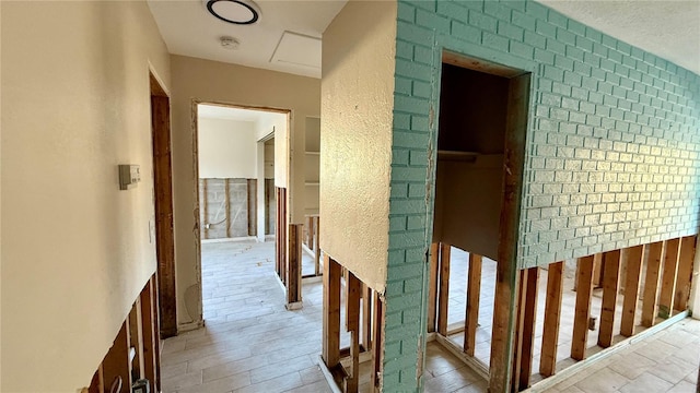 corridor with light wood-type flooring and tile walls