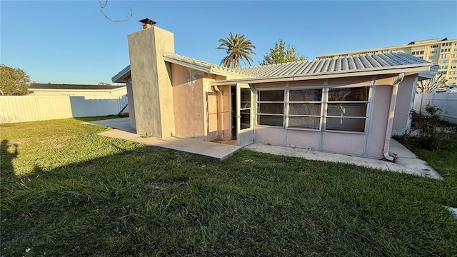 back of house featuring a lawn