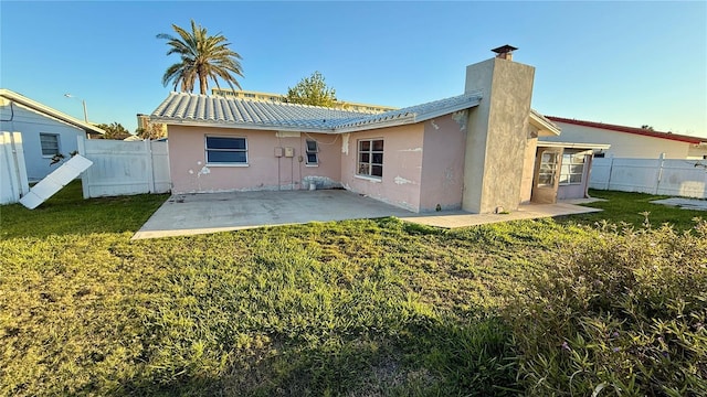 rear view of house featuring a lawn and a patio area