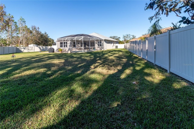 view of yard featuring a fenced backyard and a lanai