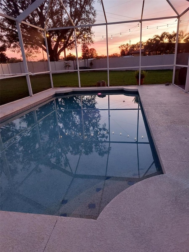 pool at dusk featuring a lanai, fence, a fenced in pool, and a patio