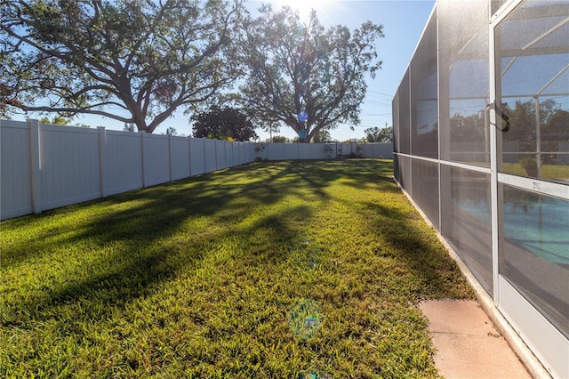 view of yard featuring a fenced backyard and a lanai