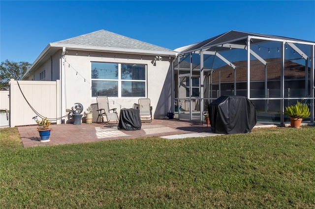 back of house featuring a lanai, a patio area, a yard, and stucco siding