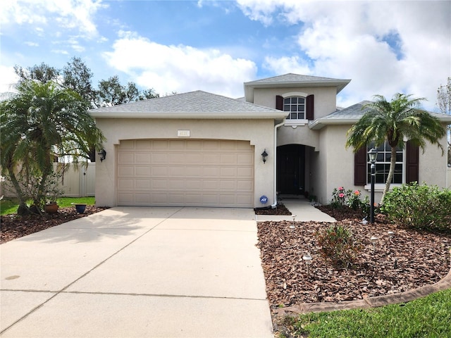 view of front of house featuring a shingled roof, driveway, an attached garage, and stucco siding