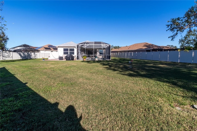 view of yard featuring glass enclosure and a fenced backyard