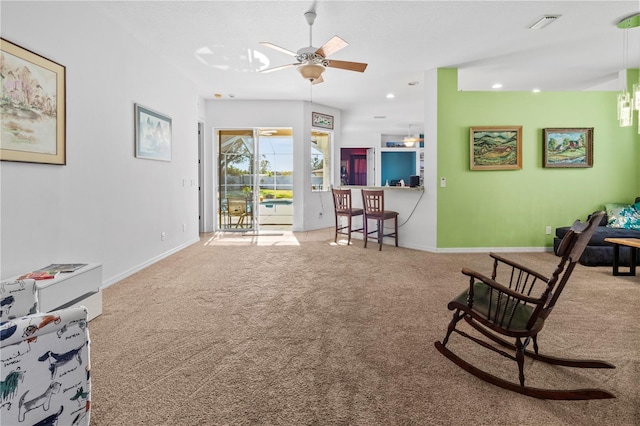 living area featuring visible vents, carpet floors, a ceiling fan, and baseboards