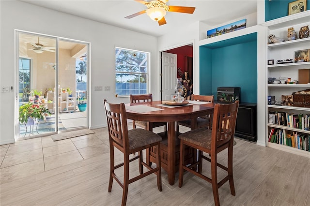 dining space with light wood-type flooring and a ceiling fan