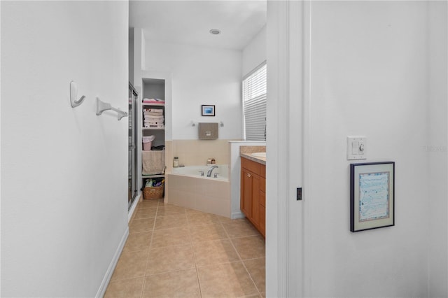 full bath with tile patterned flooring, a bath, and vanity