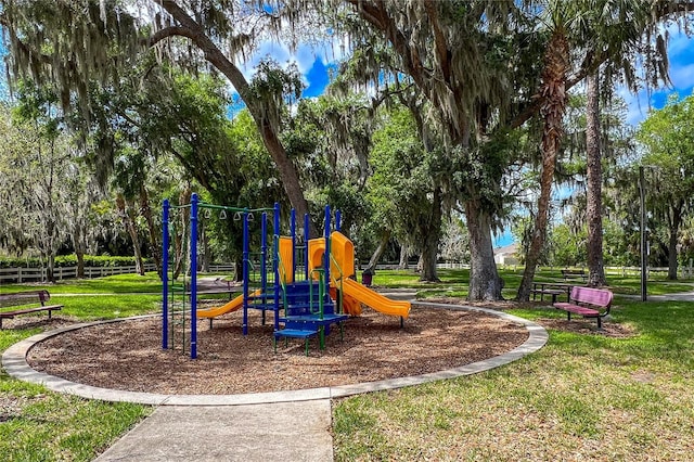 community jungle gym with a yard and fence