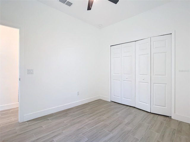 unfurnished bedroom featuring light wood-type flooring, a closet, and ceiling fan