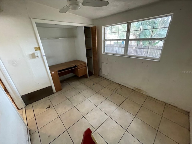 unfurnished bedroom featuring ceiling fan, light tile patterned floors, and a closet