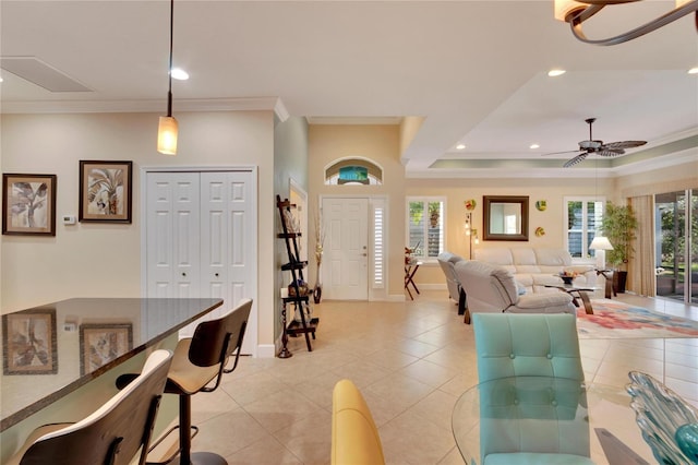 living room with plenty of natural light, ceiling fan, and ornamental molding