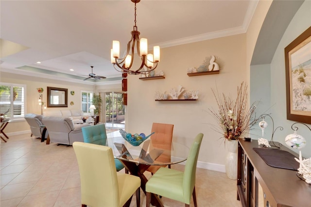 tiled dining area with ceiling fan with notable chandelier, a raised ceiling, and crown molding