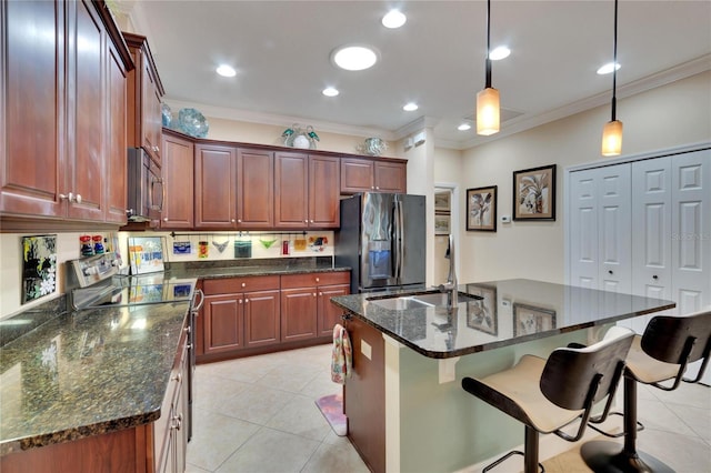 kitchen with a kitchen island with sink, crown molding, hanging light fixtures, and appliances with stainless steel finishes