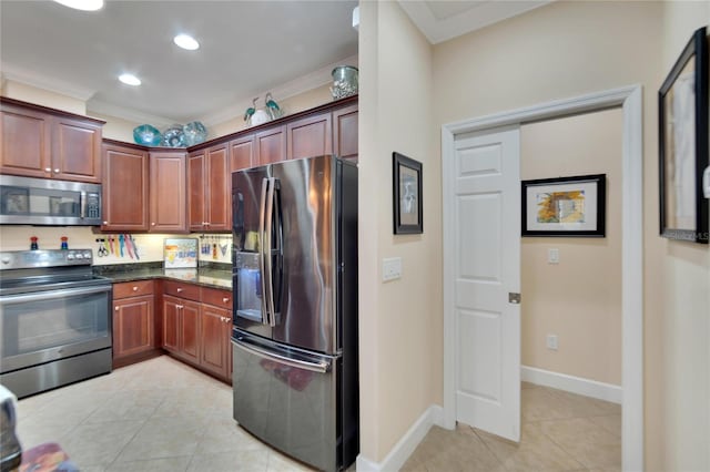 kitchen featuring crown molding, light tile patterned floors, dark stone counters, and appliances with stainless steel finishes