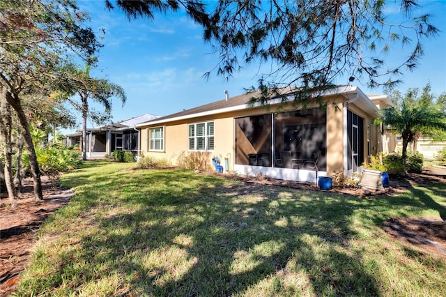 back of house with a sunroom and a yard