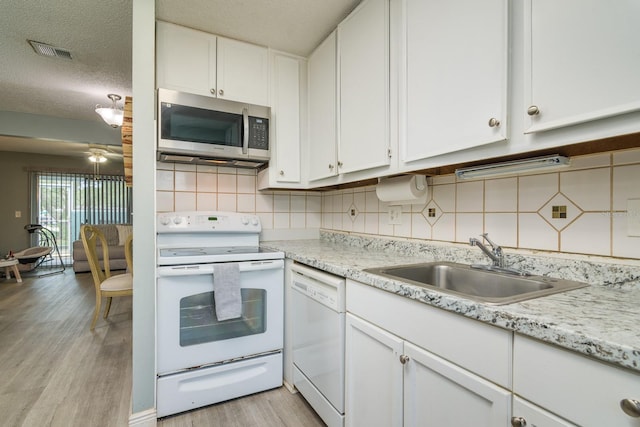 kitchen featuring white appliances, sink, decorative backsplash, light hardwood / wood-style floors, and white cabinetry