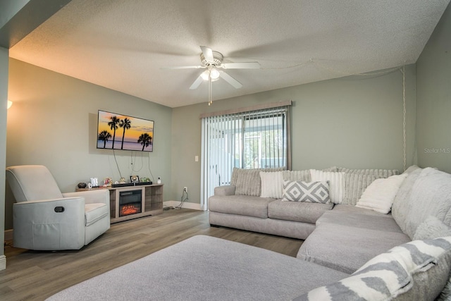 living room with ceiling fan, hardwood / wood-style floors, and a textured ceiling