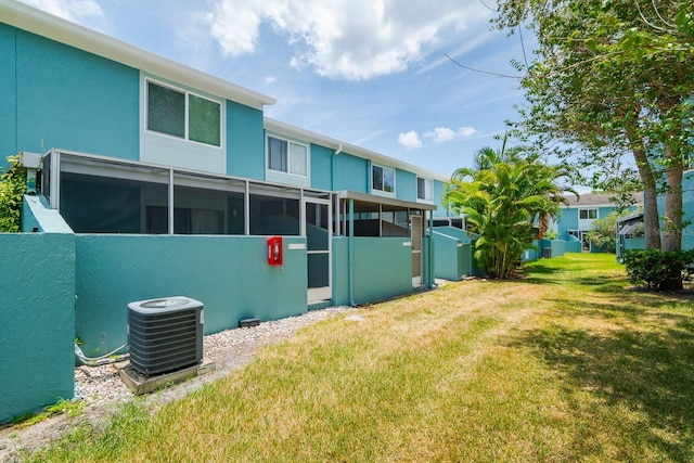 back of house with a yard and central AC