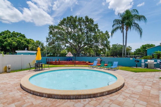 view of pool with a patio area and grilling area