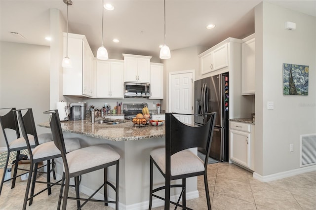 kitchen with stone counters, white cabinetry, sink, and appliances with stainless steel finishes