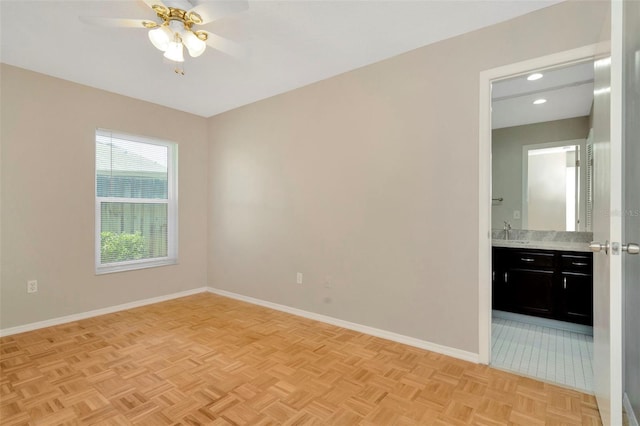 empty room with ceiling fan, sink, and light parquet floors