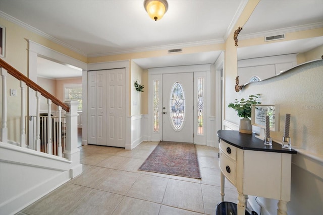 foyer entrance with ornamental molding and light tile patterned flooring