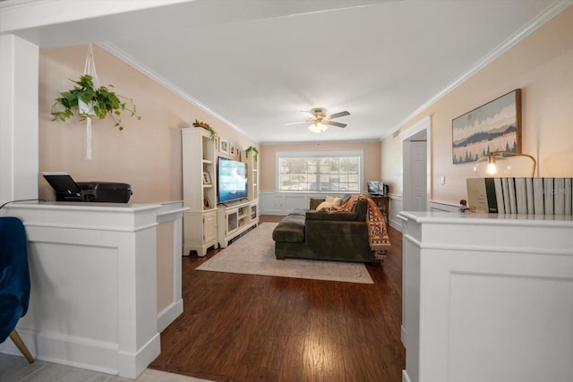 living room with dark hardwood / wood-style flooring, ceiling fan, and crown molding