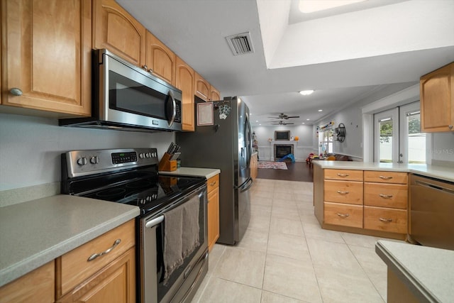 kitchen featuring ceiling fan, french doors, stainless steel appliances, crown molding, and light tile patterned floors