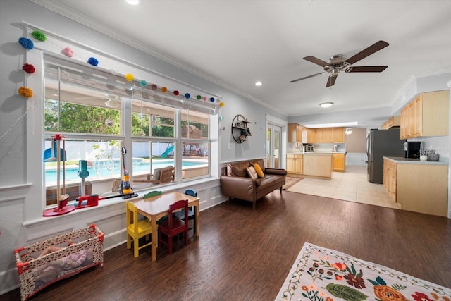 living room featuring ceiling fan, light hardwood / wood-style floors, and crown molding