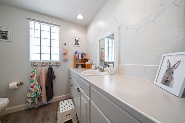 bathroom featuring vanity, hardwood / wood-style flooring, toilet, and a healthy amount of sunlight